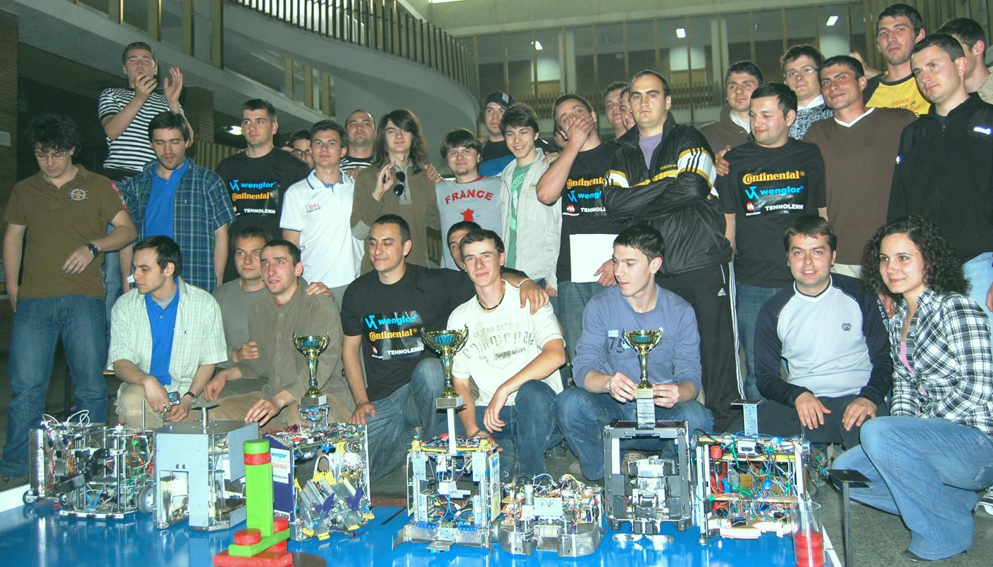 Student robotics team with competition trophies